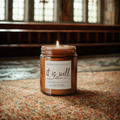 Candle in a jar with a label on a textured surface