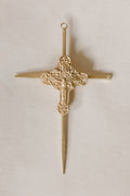 Gold cross crucifix with a nails on a light beige background