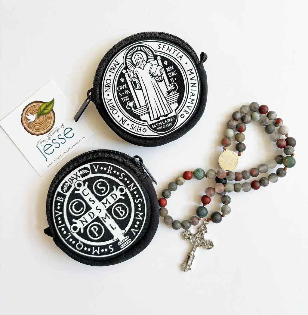 Two round black St. Benedict Medal Rosary Pouch with white designs and a rosary on a white background.