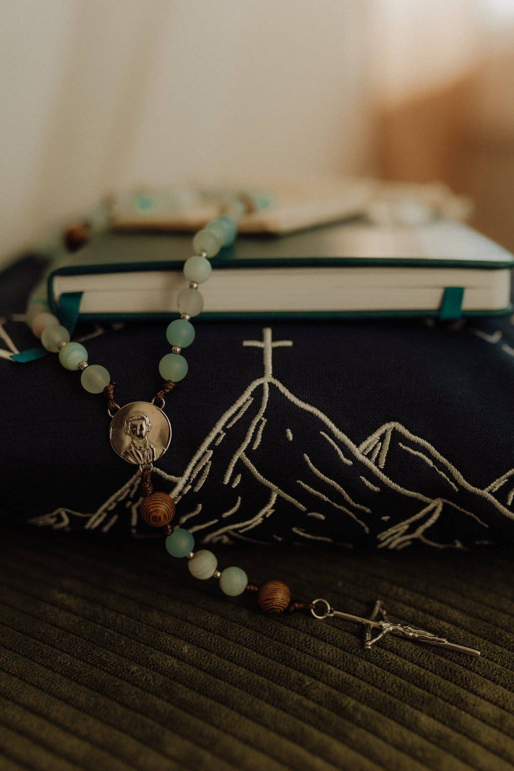Catholic Rosary with mountain design on a book