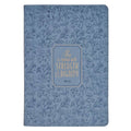 A blue notebook or journal featuring an all-over floral line pattern and a central gold-bordered label with the quote 'She is clothed with STRENGTH & DIGNITY PHIL 4:8'.