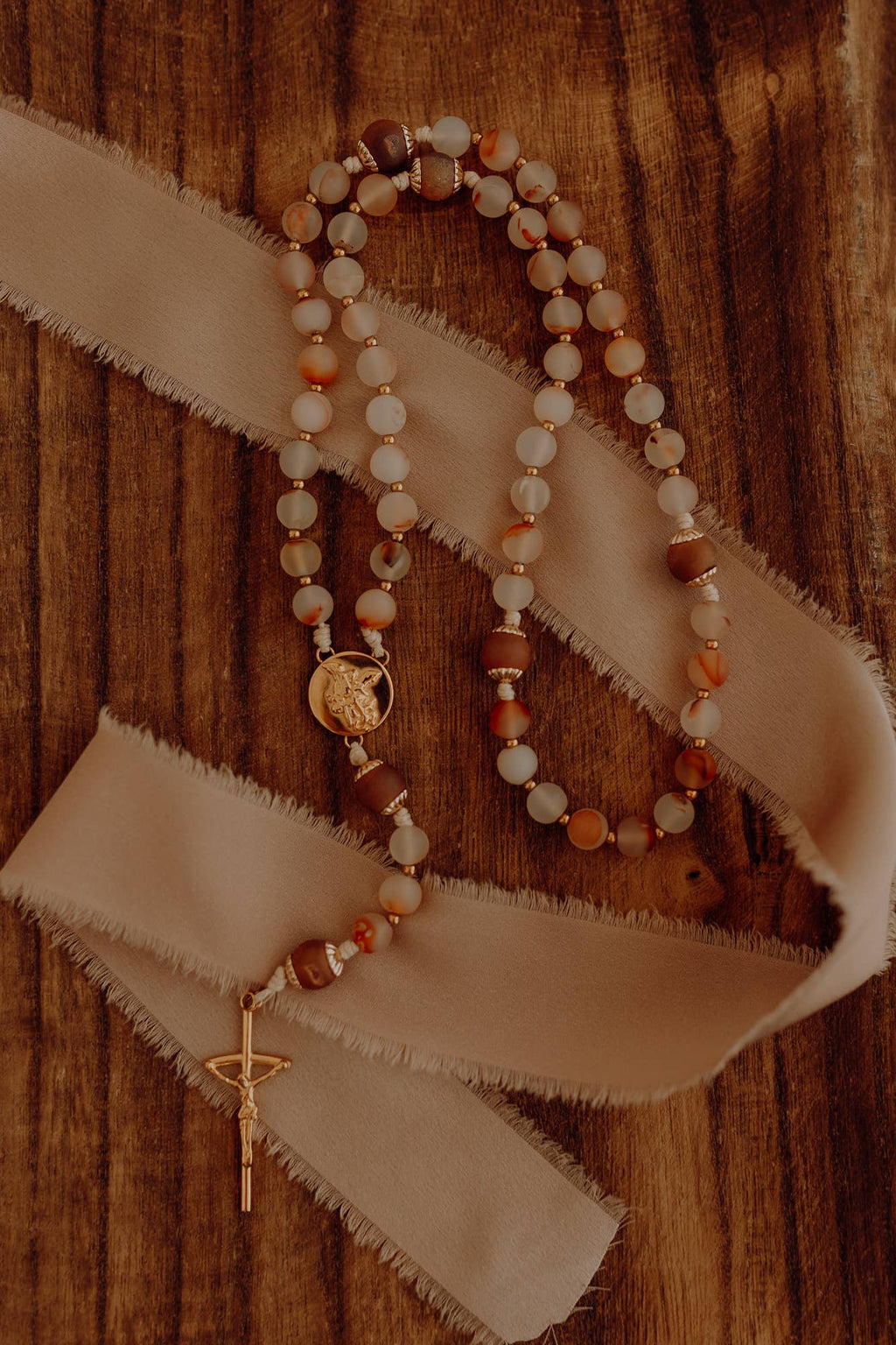 Rosary beads and a cross on a wooden surface