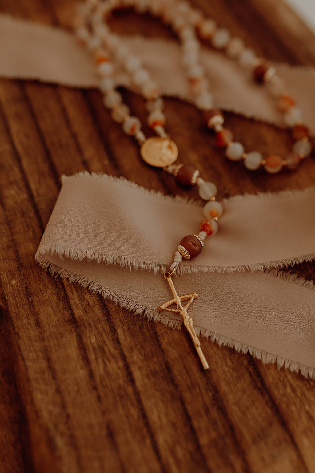 Rosary beads with crucifix on a wooden surface