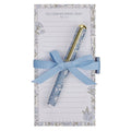 A light blue floral patterned notepad with a matching blue ribbon and gold pen tied around it, set against a plain white background.