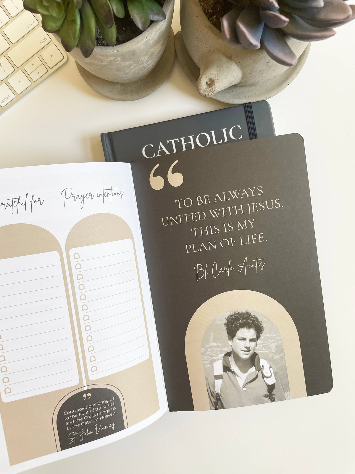 Catholic-themed book with prayer intentions on a desk with plants