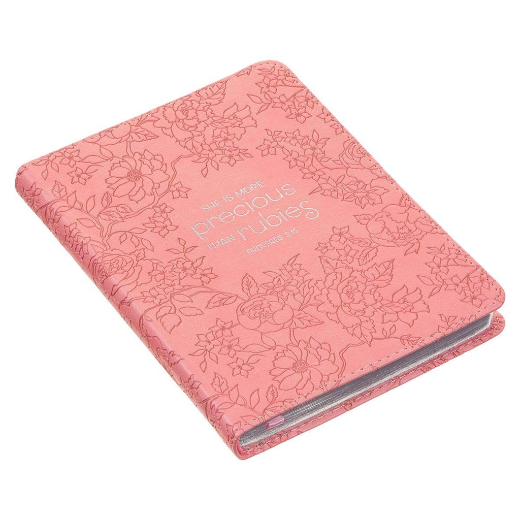 Pink notebook journal with floral embossing and text on a white background