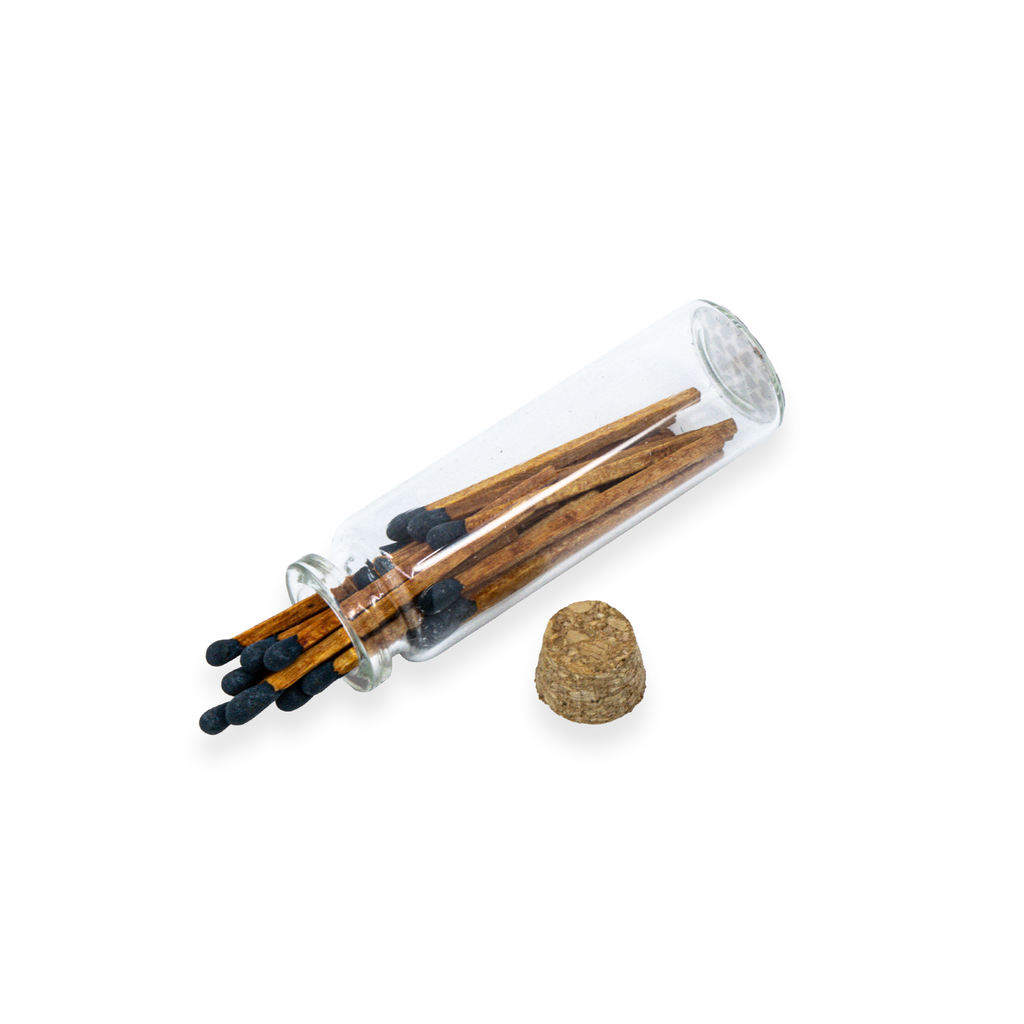 Set of matches in a glass tube with a cork stopper on a white background